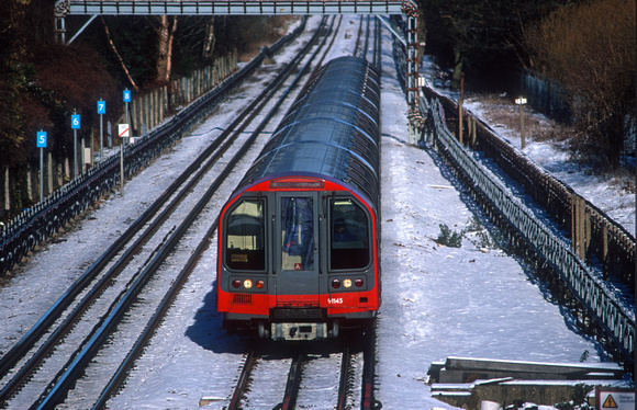 21054. Central line train in the snow. Theydon Bois. 29.1.2004