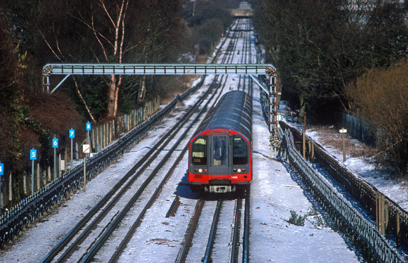21053. Central line train in the snow. Theydon Bois. 29.1.2004