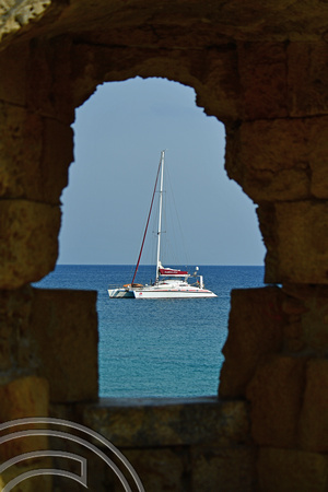 DG383032. Yacht seen through the medieval city walls. Rhodes. Greece. 19.10.2022.