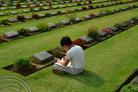 DG388680. Child recording soldiers details. War cemetery. Kanchanaburi. Thailand. 3.2.2023.
