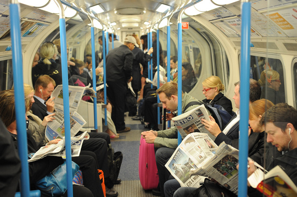 FDG24685. Reading newspapers on the Victoria line. 9.6.09.