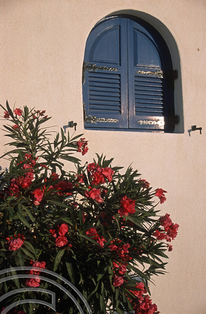 T12010. Red flowers, blue shutters. Fira. Santorini. Cyclades. Greece. 27.9.01