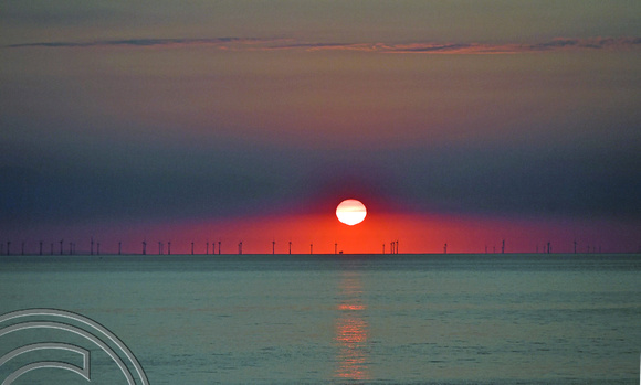 DG396903. Sunrise through wind turbines off North Wales coast. 16.6.2023.
