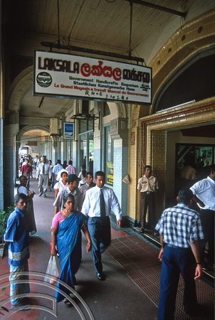 T14475. Office workers walk past the Laksala handicrafts emporium. Colombo. Sri Lanka. 30.12.02