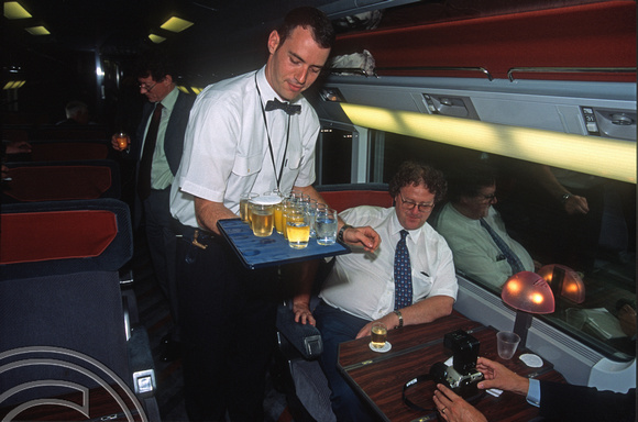 12626. Steward serving glasses of champagne to celebrate the record breaking run. HS1. 30.7.03