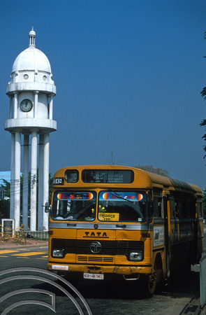 T14452. Local bus and one of the countries many clock towers. Cinnamon Gardens. Colombo. Sri Lanka. 29.12.02