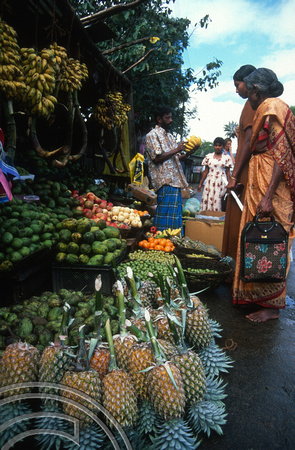 T14914. Women buy fruit from a stall by the railway station. Haputale. Sri Lanka. 8.1.03.