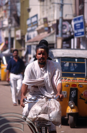 T6451. Pilgrim cycling to the temple. Madurai. India. January.1998