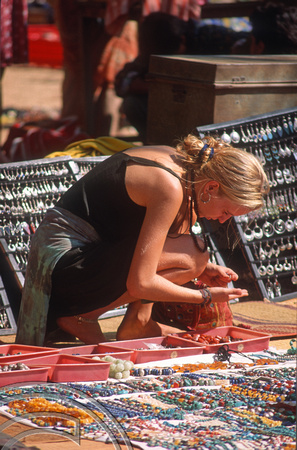T4484. Tourist shopping for beads at the Flea market. Anjuna. Goa. India. December 1993.