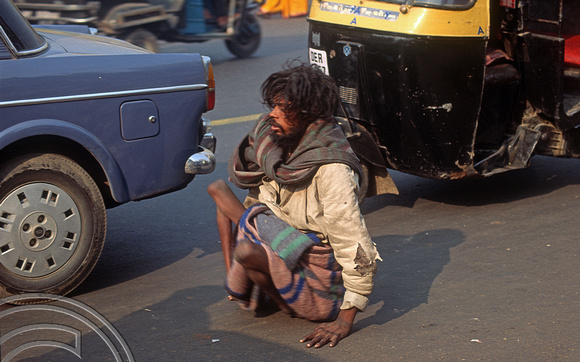T4590. Crippled man dodging traffic. Paharganj. Old Delhi. India. January 1994.
