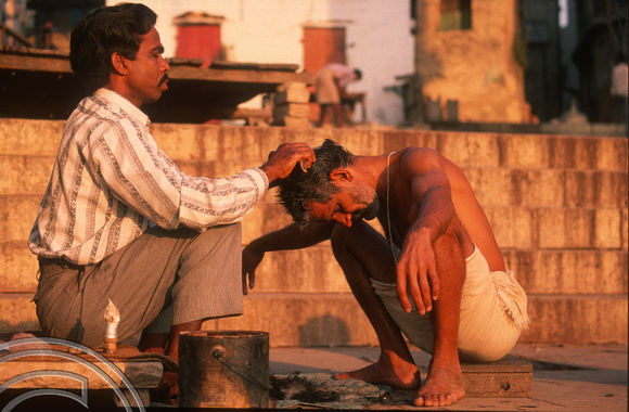 T6855. Pilgrim getting a haircut at the ghats. Varanasi. Uttar Pradesh. India. February 1998. jpg