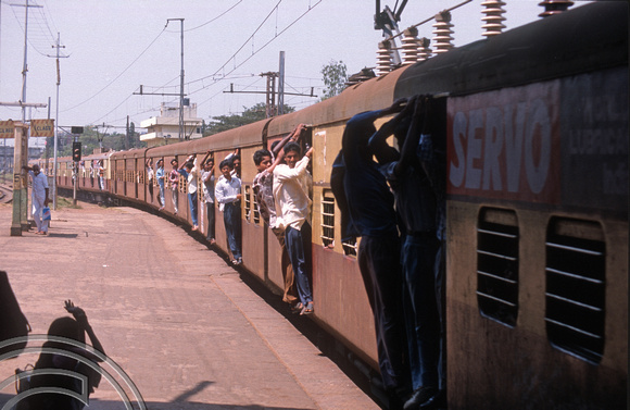 T6678. Commuters door-hanging. Egmore railway station. Chennai. Tamil Nadu. India. February 1998