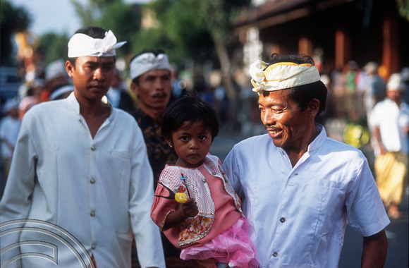 T015952. Man and daughter in a procession. Ubud. Bali. Indonesia. 19th September 2003