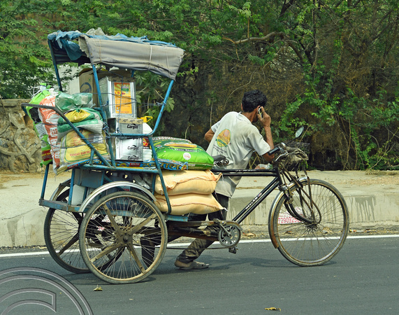 DG291348. Rickshaw wallah on his phone. Delhi. India. 4.3.18