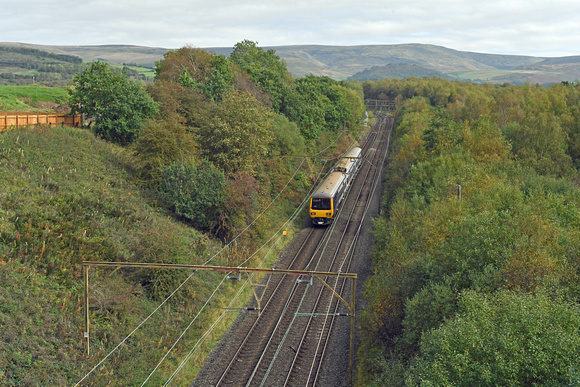 DG404436. 323235. 2G14. 1233 Manchester Piccadilly to Hadfield. Passes the site of Mottram reception sidings. 12.10.2023.