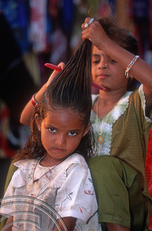 T12960. Girl having her hair brushed. Arambol. Goa. India. 4th February 2002