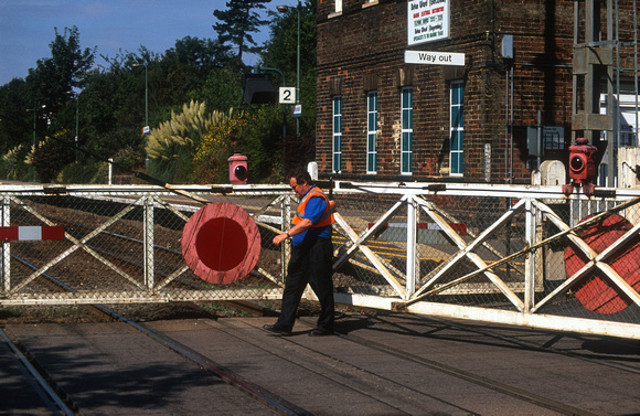 12956. Crossing keeper closes the gates. Brundall. 03.09.2003
