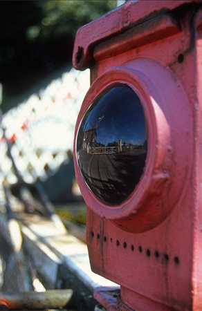 12954. Crossing gates reflected in an old oil lamp. Brundall. 03.09.2003