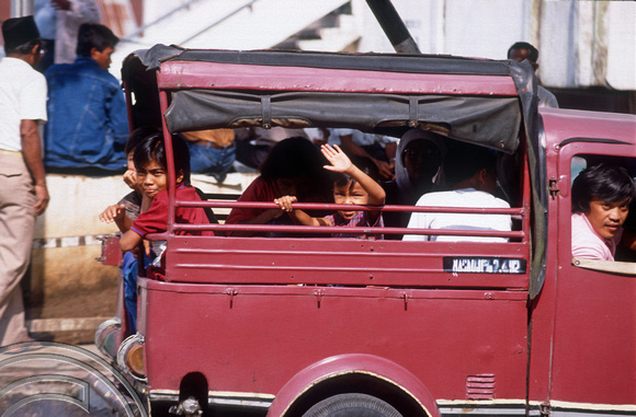 T03637. Kids wave from a van. The market. Bukittinggi. West Sumatra. Indonesia. 3rd June 1992