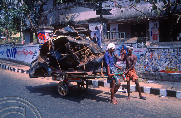 T03153. Crushed taxi on a cart. Trivandrum. Kerala. India. 1st February 1992.