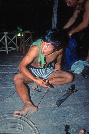 T03818. Preparing rattan to weave a bracelet. Mentawai Islands. Indonesia. 22nd June 1992