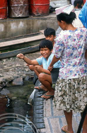 T03595. Children fishing froma boat. Prapat. Samosir Island. Lake Toba. North Sumatra. Indonesia. 30th May 1992
