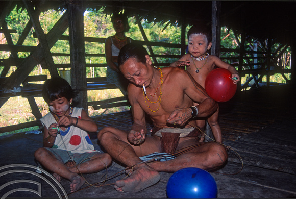 T03817. Preparing rattan to weave a bracelet. Mentawai Islands. Indonesia. 22nd June 1992