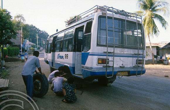 T04058. Fixing a puncture on the bus to Ruteng. Flores. Indonesia. 6th September 1992