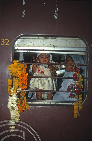 T9658. Baby looking out of a train. Rajkot. India. 12.02.2000