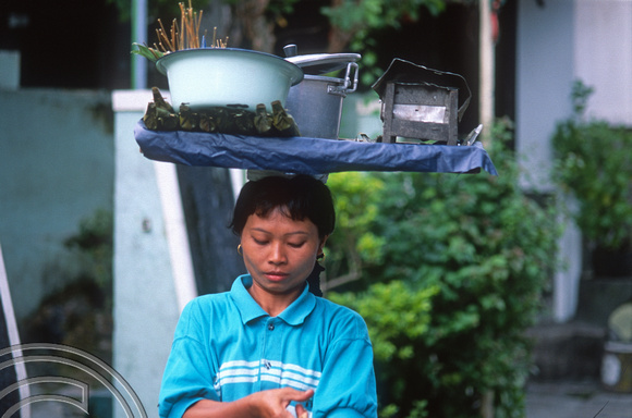 T8354. Woman carrying her stall on her head. Yogyakarta. Java. Indonesia. December 1998