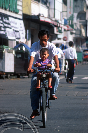 T8360. Man and baby on a bicycle. Yogyakarta. Java. Indonesia. December 1998