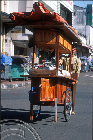 T8362. Hawker pushing his food stall. Yogyakarta. Java. Indonesia. December 1998