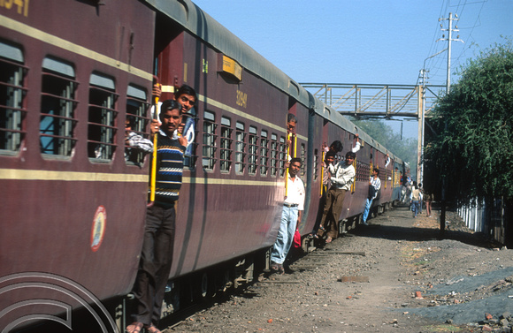 FR0588. People hanging from the Patan - A'bad Express. Ahmedabad. Gujarat. India. 16.02