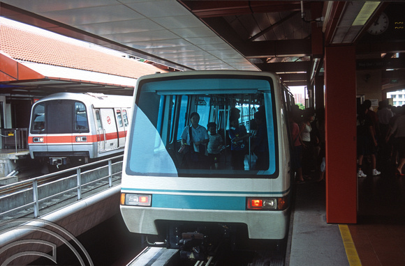 FR1115. MRT trains calls whilst passengers board the LRT. Choa Chu Kang MRT. Singapore. 09.09.2003