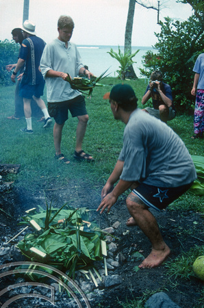 T9131. Placing food in the fire pit. Piri Purito's. Rarotonga. Cook Islands. March 1999