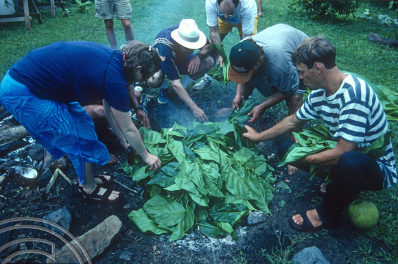 T9135. Placing food in the fire pit. Piri Purito's. Rarotonga. Cook Islands. March 1999