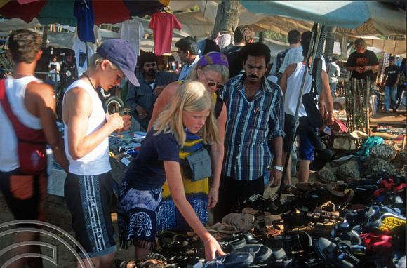T9419. Shopping for shoes. Anjuna flea market. Goa. India. 2nd February 2000
