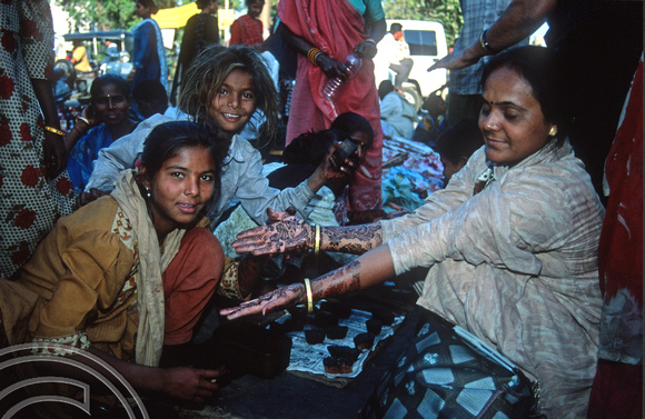 T9761. Girls painting henna designs on hands. Ahmedabad. Gujarat. India. 16th February 2000