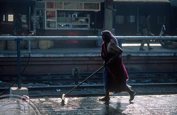 T9830. Woman washing the station platform. Ahmedabad. Gujarat. India. 21st February 2000