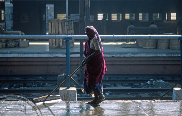 T9831. Woman washing the station platform. Ahmedabad. Gujarat. India. 21st February 2000