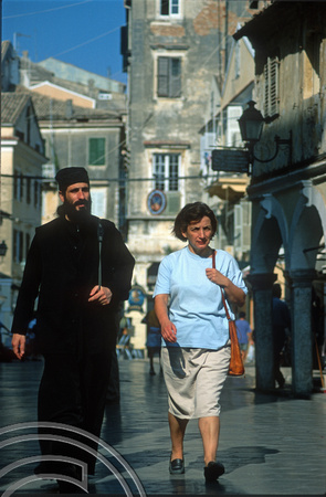 T10170. Woman and priest walking in the old town. Corfu. Ionian Isles. Greece. 26th September 2000