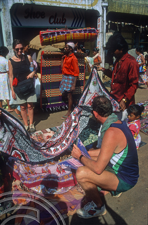 T5693. Shopping for bedspreads in the market. Mapusa. Goa. India. December 1995